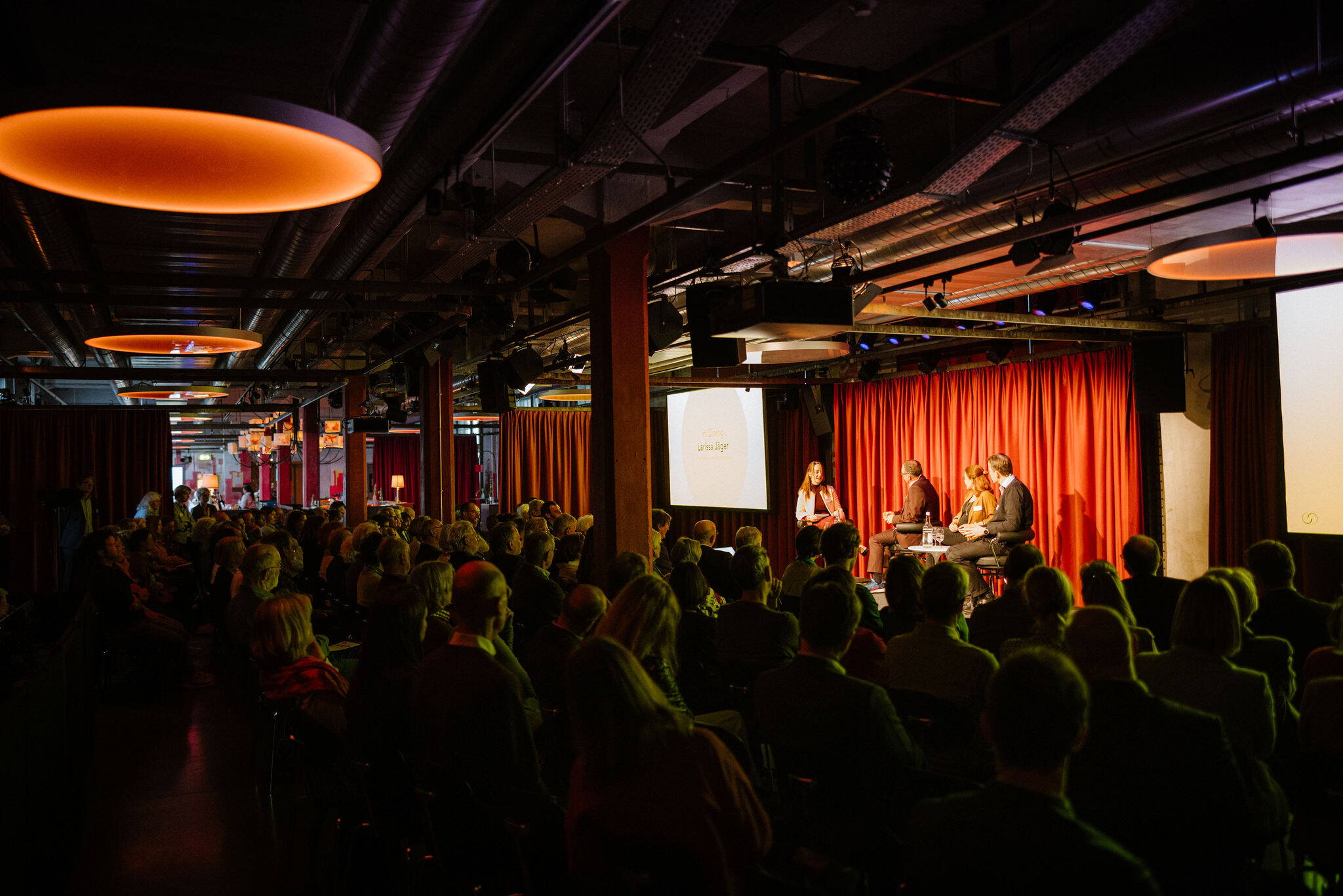 Referat/Konferenz im Papiersaal Referat/Konferenz im Papiersaal, Menschen sitzen, Redner:innen auf Bühne